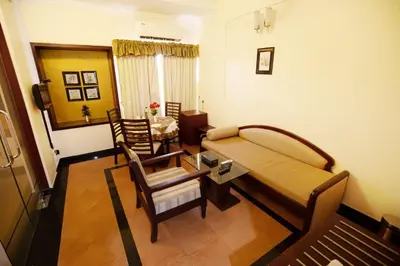 a room with a bed and a table and chairs at Hotel Afrad International in Kondotti