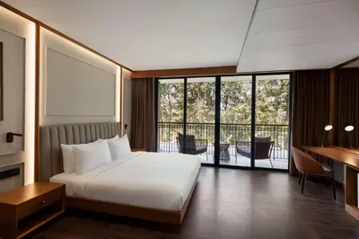 a hotel room with a bed and a balcony at Morickap Lord's 83, Trademark Collection by Wyndham in Meenangadi