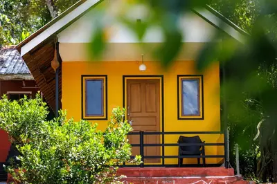a small yellow house with a front porch at Birds Island Ayur-Yoga Retreat in Ernakulam