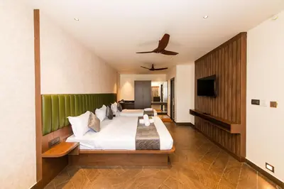 a bedroom with a large bed with a green headboard at Hotel Mysore Radiance in Mysore