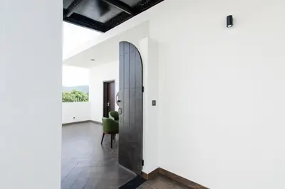 a pivot door in a room with a green chair at Hotel Mysore Radiance in Mysore