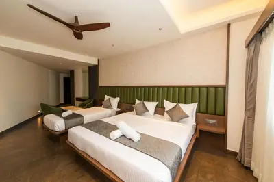 a bedroom with two beds and a ceiling fan at Hotel Mysore Radiance in Mysore