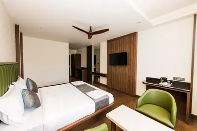 a hotel room with a bed and a desk and chair at Hotel Mysore Radiance in Mysore