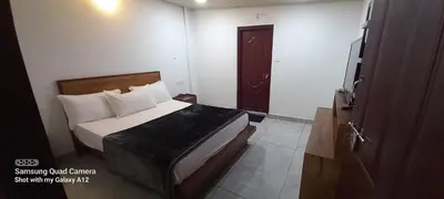 a bedroom with a bed in a room with a door at Perumaal Homestay in Munnar