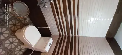 a bathroom with a toilet and a mirror at Perumaal Homestay in Munnar