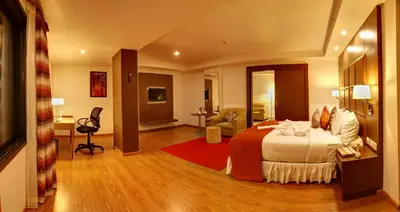 a hotel room with a bed and a living room at The Atrium Boutique Hotel in Mysore