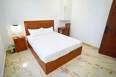 a bedroom with a large bed with a wooden frame at GH Grand Park in Angamali