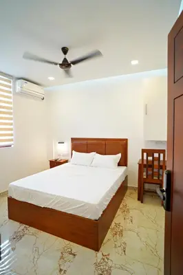 a bedroom with a bed and a ceiling fan at GH Grand Park in Angamali