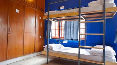 a bedroom with two bunk beds and a blue wall at Roambay - Gokulam in Mysore