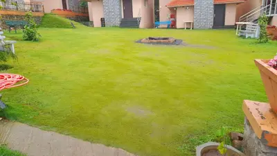 a yard with a green lawn with a fire pit at Royal Crown resorts in Kotagiri