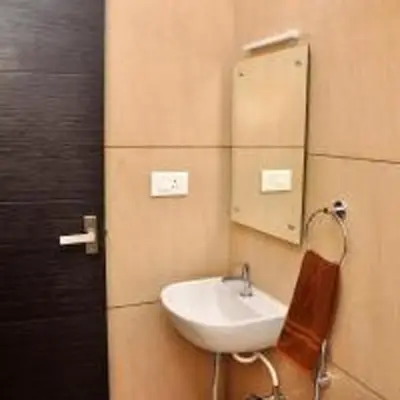 a bathroom with a sink and a mirror on the wall at Harikrishna Park in Coimbatore