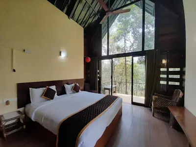 a bedroom with a large bed and a large window at Gorukana Eco Wellness Centre in Honganūr