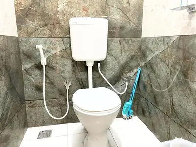 a white toilet in a bathroom with a shower at Mannat Inn Classic Premium - 3BHK in Mysore