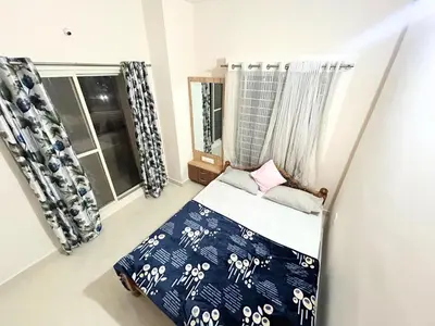 a small bedroom with a bed and a window at Mannat Inn Classic Premium - 3BHK in Mysore