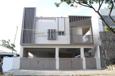 a white house with a fence in front of it at Sapna residency in Mettuppālaiyam