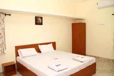 a bedroom with a bed with two towels on it at Sapna residency in Mettuppālaiyam