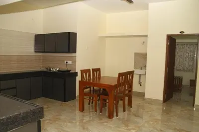 a kitchen and dining room with a table and chairs at Sapna residency in Mettuppālaiyam