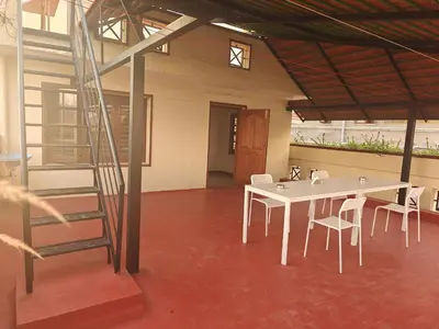 a room with a table and chairs and a staircase at Emerald Luxury Villa in Mysore