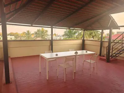 a white table and chairs in a room with windows at Emerald Luxury Villa in Mysore