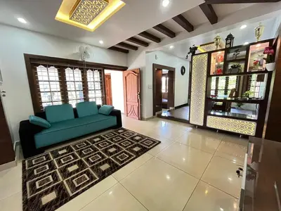 a living room with a blue couch and a rug at Le Casabella in Kalpetta