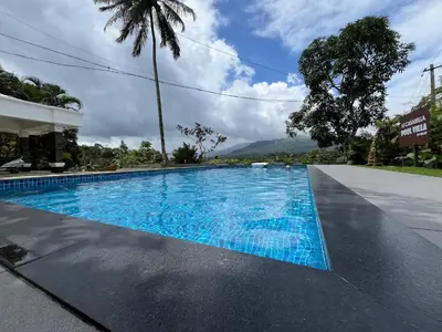 a swimming pool with blue water in front of a building at Le Casabella in Kalpetta