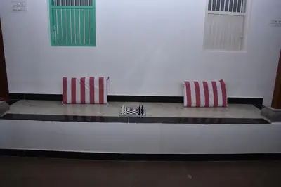 two red and white pillows sitting on a white wall at Beyond Ghatts Homestay in Dhali