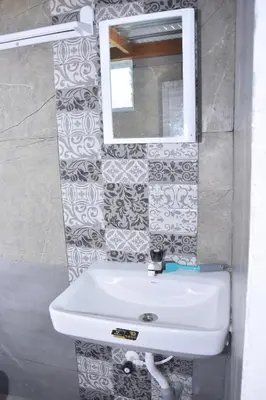 a bathroom with a white sink and a mirror at Beyond Ghatts Homestay in Dhali
