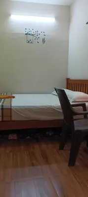 a bed in a room with a table and a chair at KPR Residency Near Isha - Adiyogi in Alāndurai