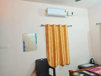 a mirror and a curtain in a room at KPR Residency Near Isha - Adiyogi in Alāndurai