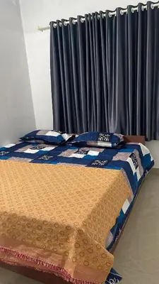a bed in a room with a window with curtains at Scott legacy apartment in Kulattūr