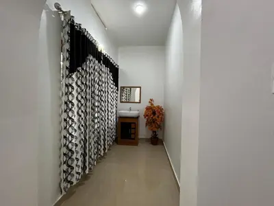 a hallway of a house with a wall of logs at Puzhayoram Homestay in Trichūr