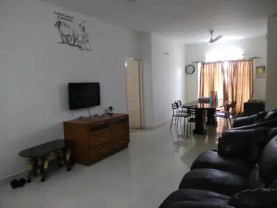 a living room with a couch and a tv and a table at Gerones Residency Serviced Apartments & Home Stays in Coimbatore
