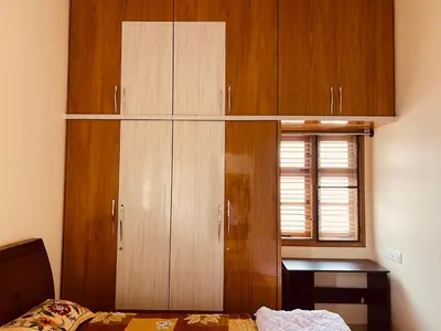 a bedroom with wooden cabinets and a bed and a window at A B House in Kollegālam