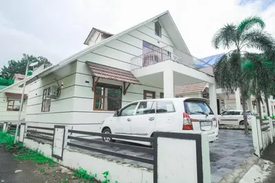 a white car parked in front of a house at Green Nest Villa at Athirappilly in Athirappilly