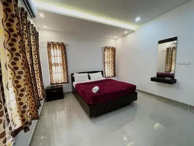 a bedroom with a bed with a red bedspread at Green Nest Villa at Athirappilly in Athirappilly