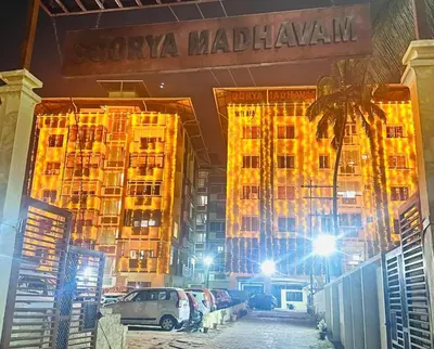 a large building with cars parked in front of it at Gokulam By Upasana in Guruvāyūr