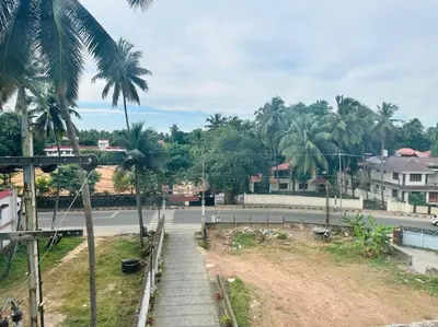 a street with palm trees on the side of a road at Gokulam By Upasana in Guruvāyūr