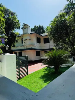 a large building with a fence and a yard at Dream House Near IIM Kozhikode & NIT Calicut in Kozhikode