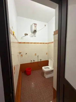 a bathroom with a toilet and a camera on the wall at Dream House Near IIM Kozhikode & NIT Calicut in Kozhikode