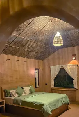 a bedroom with a green bed in a room at Nelli Mud Village in Thirunelli