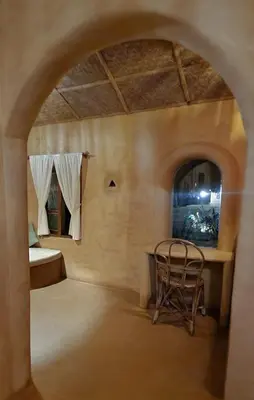 a room with a table and a chair at Nelli Mud Village in Thirunelli
