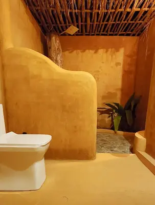 a bathroom with a toilet in a room at Nelli Mud Village in Thirunelli