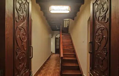 a hallway with two sets of doors and stairs at The Humming Bird A Stay Chapter in Ooty