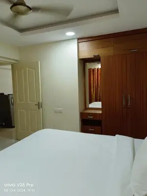 a bedroom with a bed and a closet and a mirror at VVP service Apartments in Nedumbassery