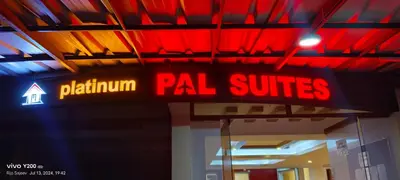 a neon sign for apal suites in a building at VVP service Apartments in Nedumbassery