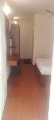 a small room with a bed and a cabinet at GEM Stays in Ooty