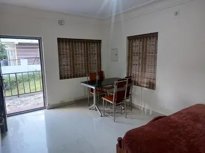 a bedroom with a table and chairs and a bed at GEM Stays in Ooty