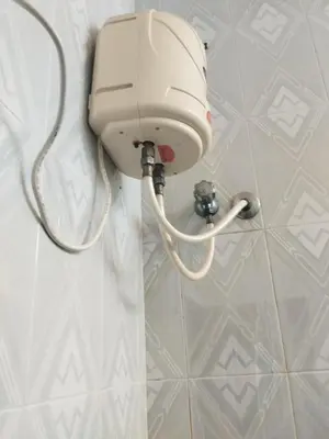 a white phone hanging on a wall in a bathroom at Kumarasamy House in Tiruchengodu