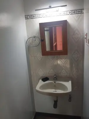 a bathroom with a sink and a mirror at Kumarasamy House in Tiruchengodu