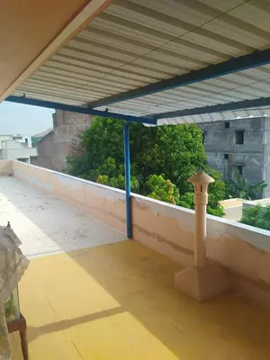 a patio with awning and a table on a roof at Kumarasamy House in Tiruchengodu